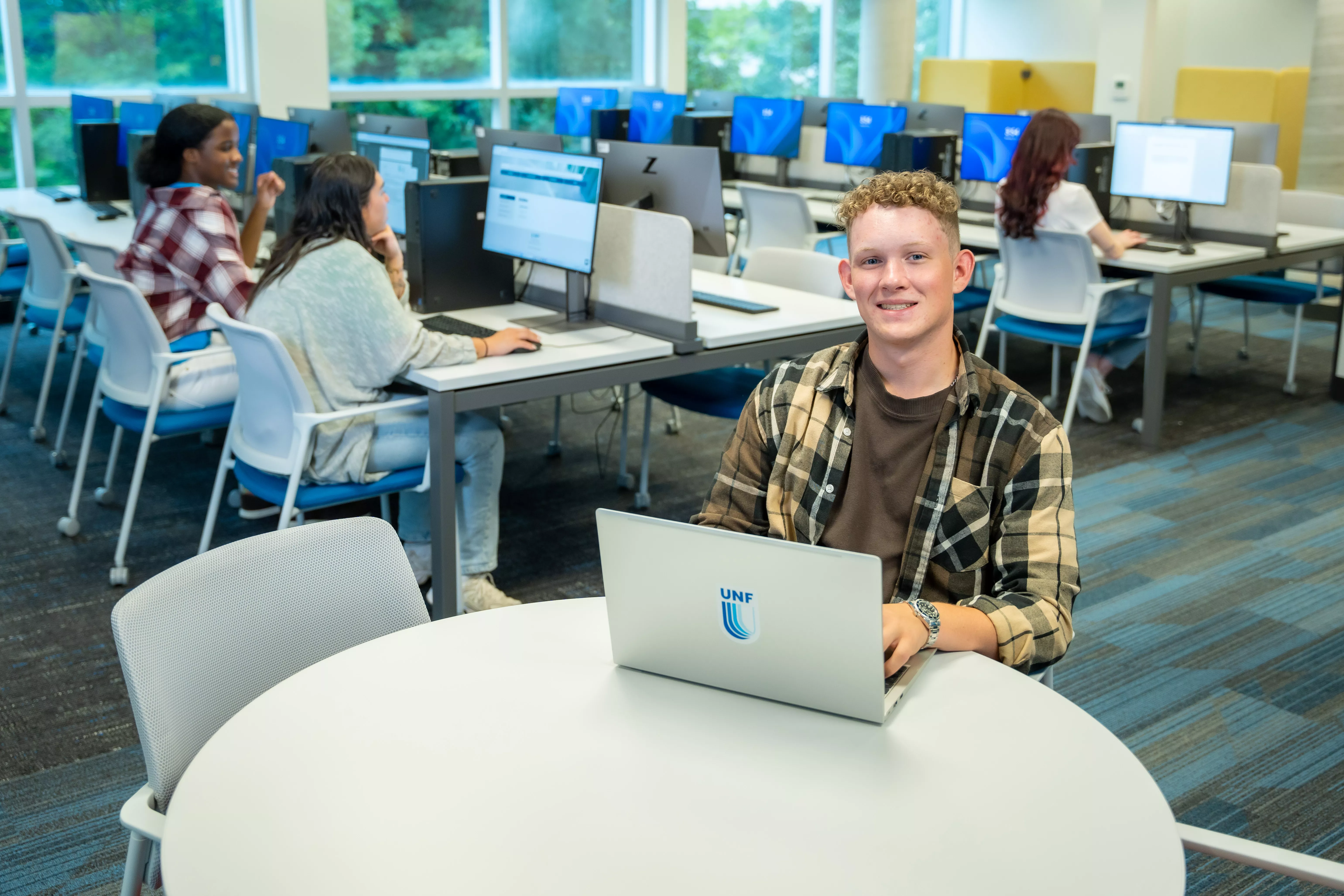 People sitting in library, red headed male facing the camera